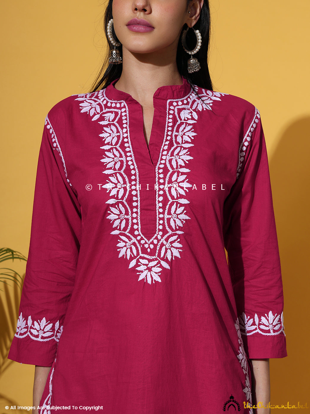 Elegant short hot pink Chikankari kurti with matching pants, designed with floral white embroidery. Buy cotton Chikankari kurti set online for a bold ethnic look.