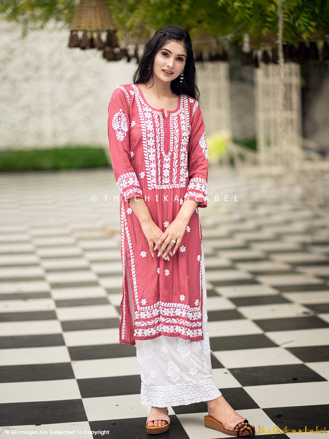Woman in coral muslin kurti with traditional white embroidery