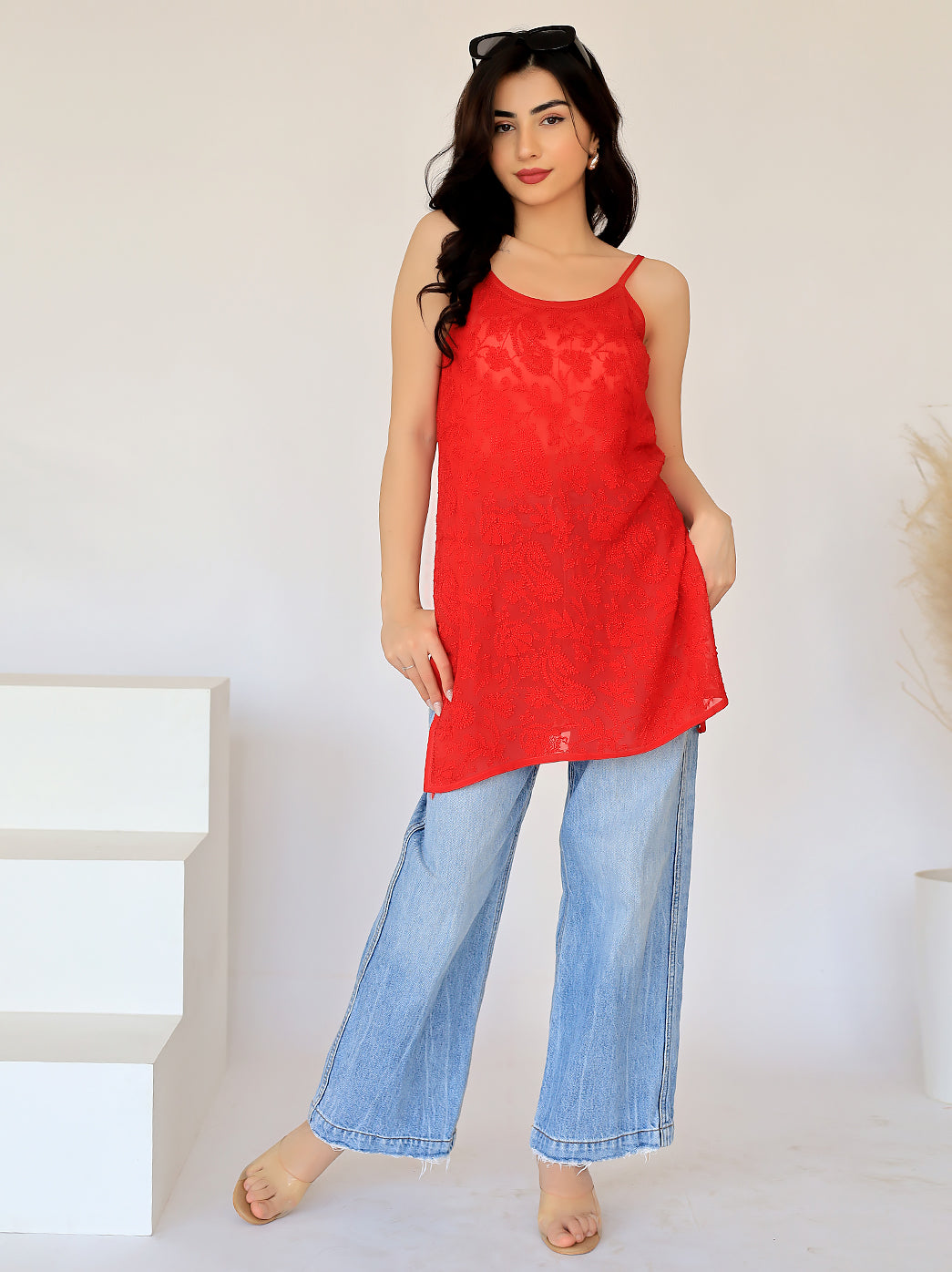 Woman wearing a vibrant red strappy chikankari short kurta