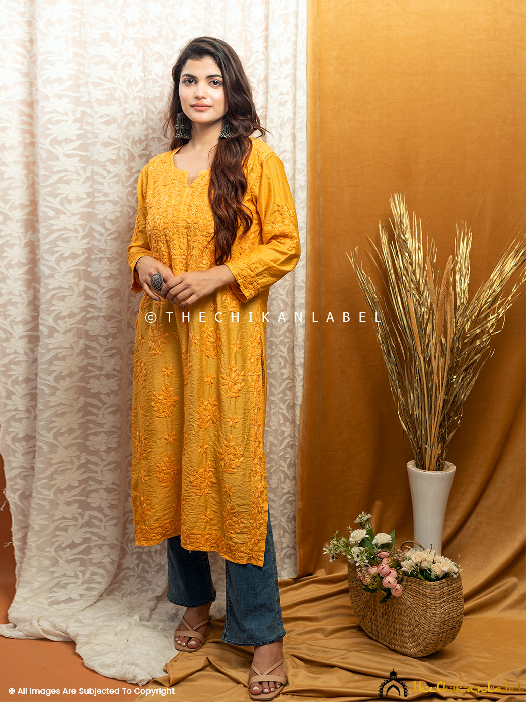 Woman wearing a yellow chanderi straight-fit kurti with tonal hand-embroidered chikankari detailing.