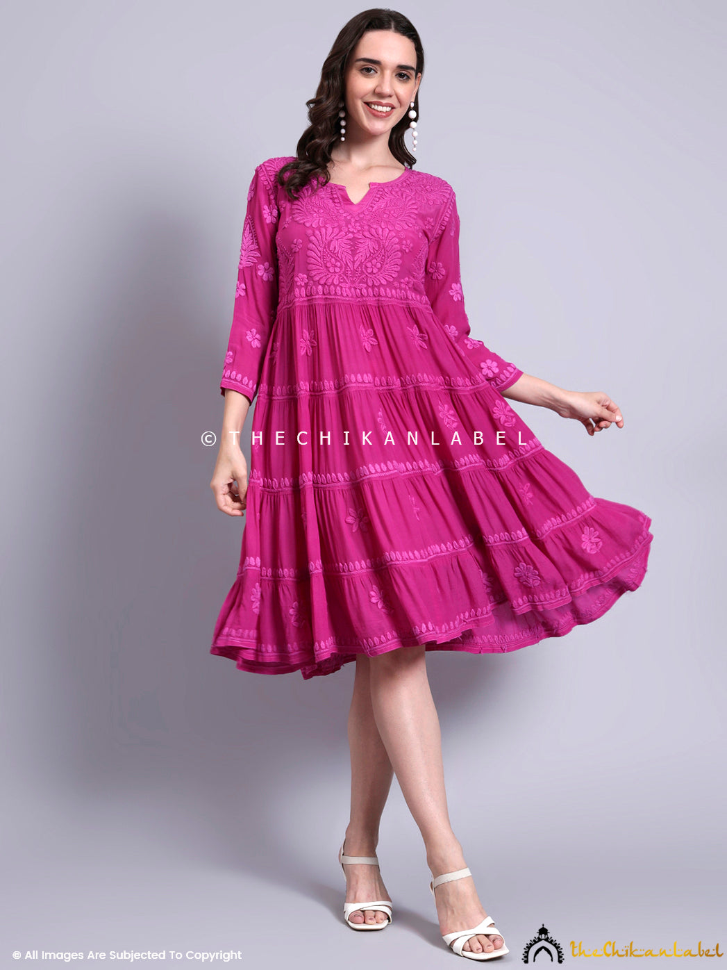 Woman wearing crepe chikankari tier tunic gown with handcrafted floral embroidery and flared silhouette.