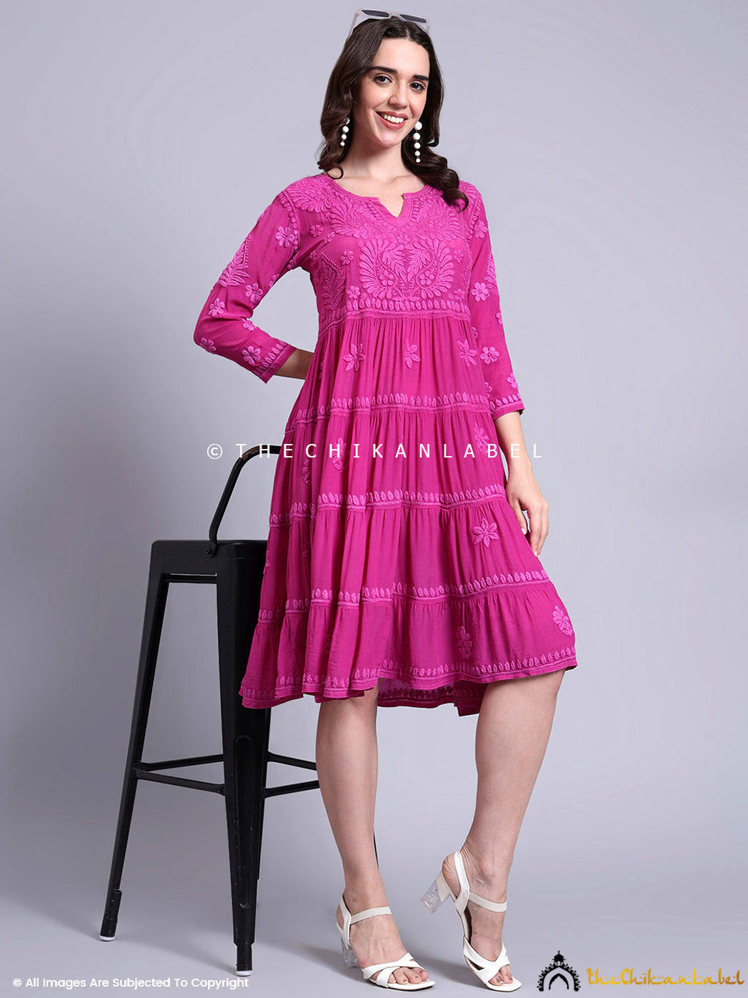 Flared crepe tunic gown with handcrafted details worn by model in traditional fashion.