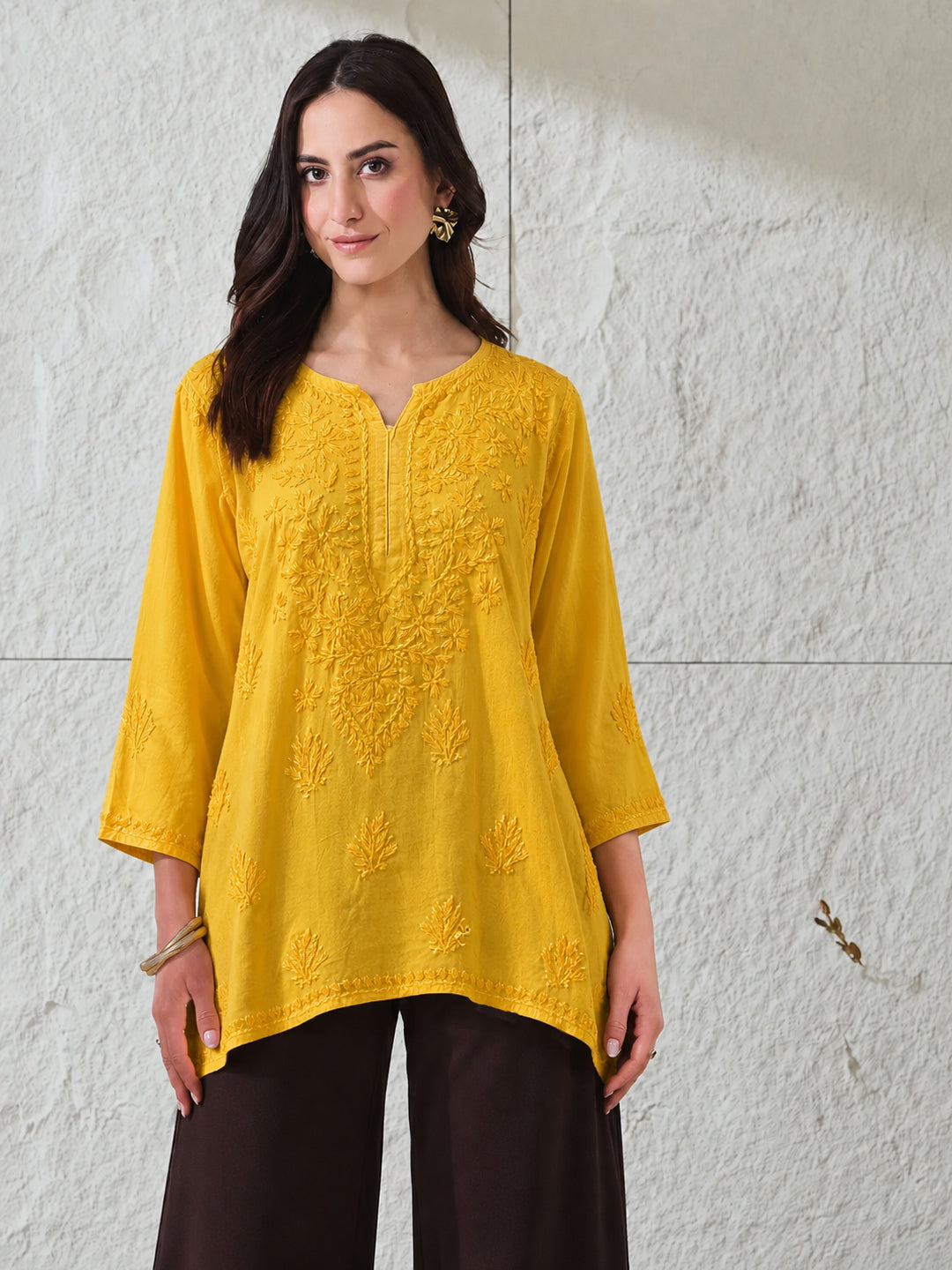 Trending Chikankari top for women made from soft rayon fabric with intricate embroidered floral motifs, relaxed short kurti silhouette and elegant everyday appeal.