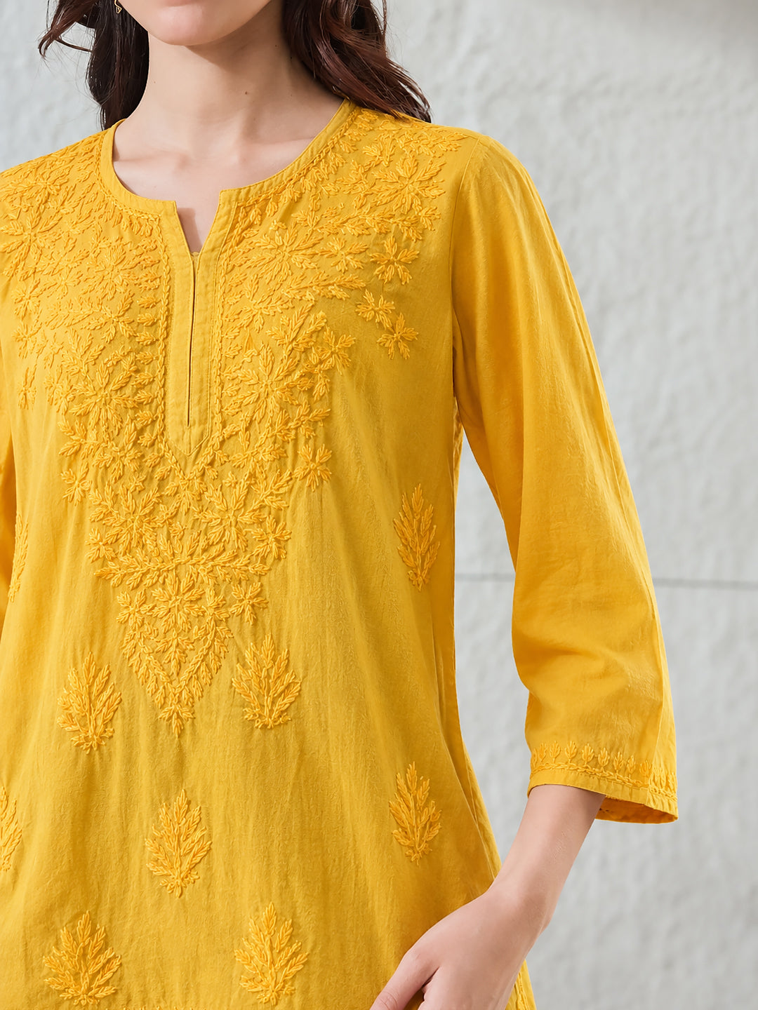 Trending Chikankari top for women made from soft rayon fabric with intricate embroidered floral motifs, relaxed short kurti silhouette and elegant everyday appeal.