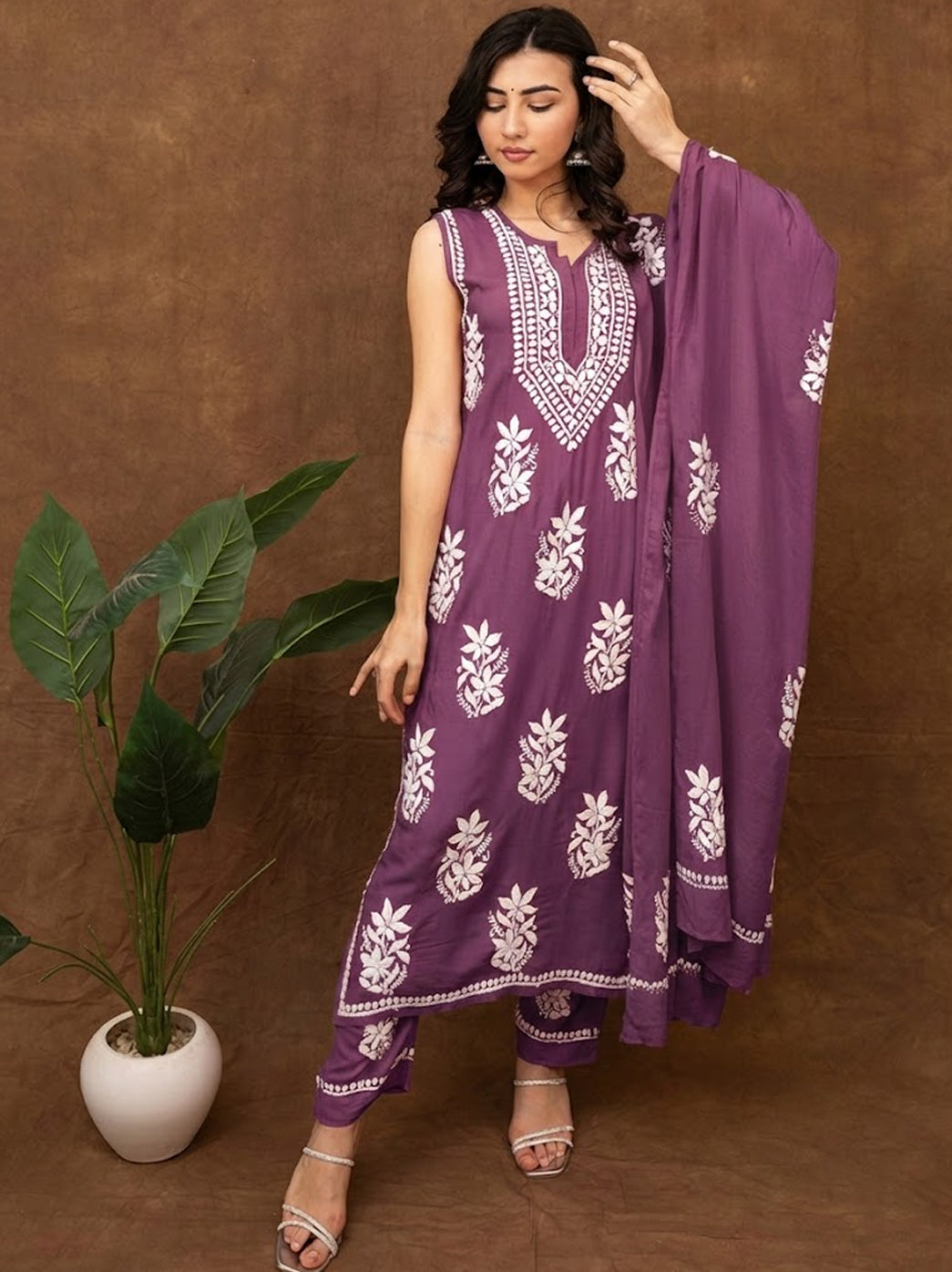 Classic chikankari kurta set featuring delicate hand embroidery, sleeveless styling, embroidered bottoms, and dupatta for graceful traditional looks