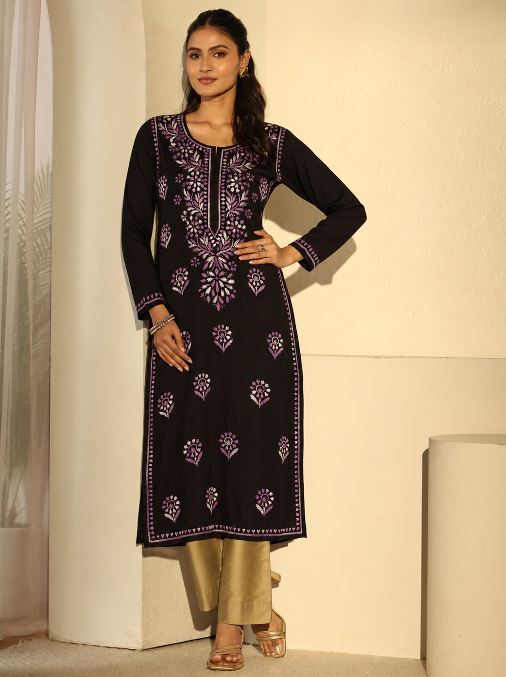 Full-length fashion photograph of a model in the Ayra Rayon Straight Kurti, highlighting its three-quarter sleeves, rounded slit neckline, side openings and floral Chikankari detailing.