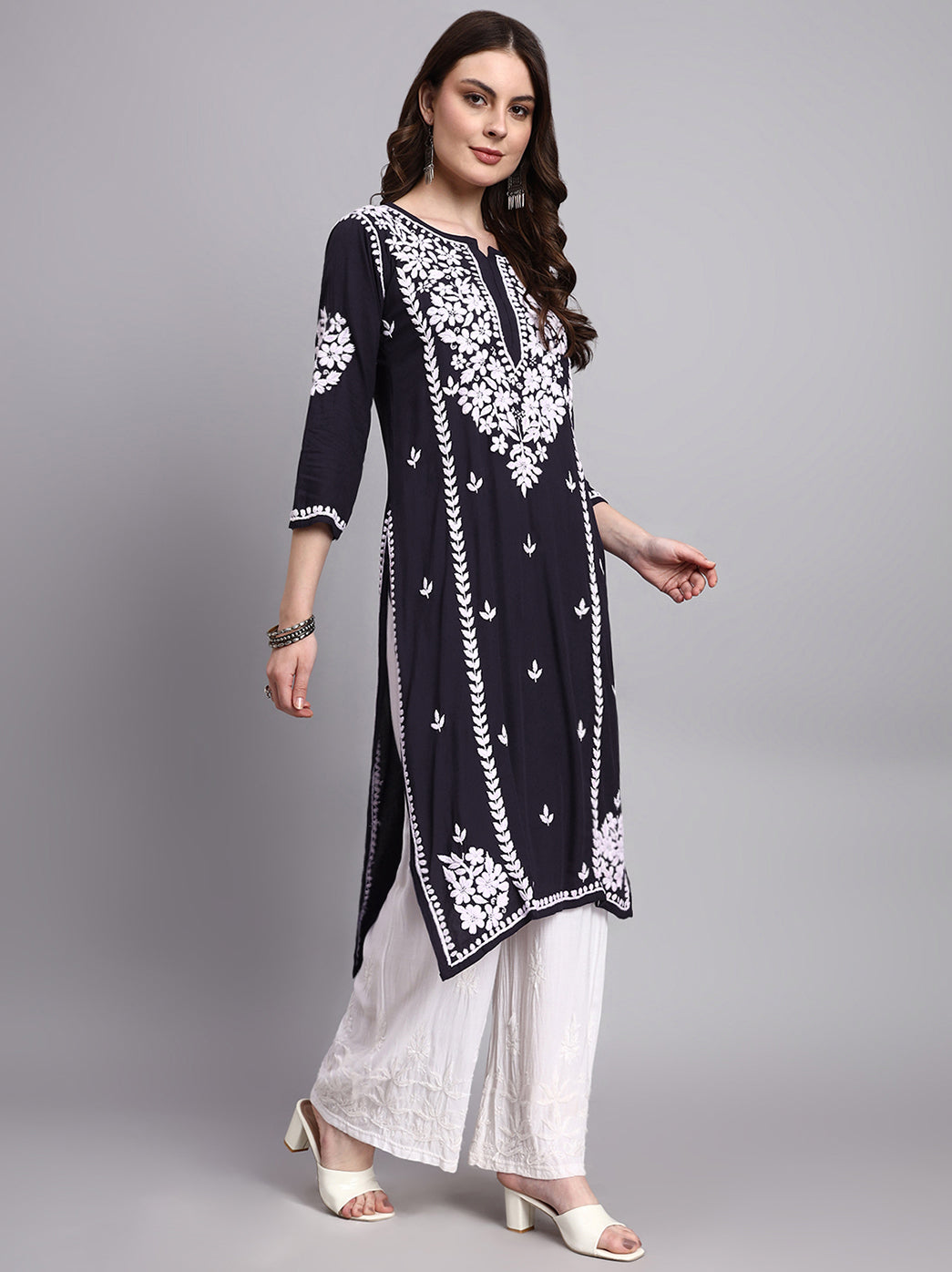 Woman wearing a rayon chikankari long kurta featuring handcrafted floral embroidery with straight fit silhouette and elegant neckline design