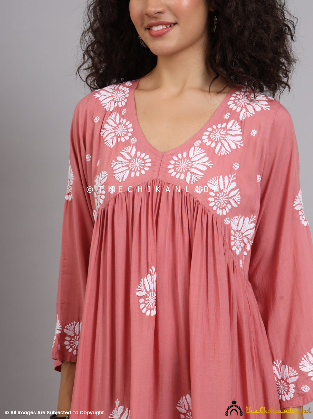 Handcrafted coral Alia-cut kurti featuring gathered pleats and floral chikankari embroidery, perfect for festive or casual styling.