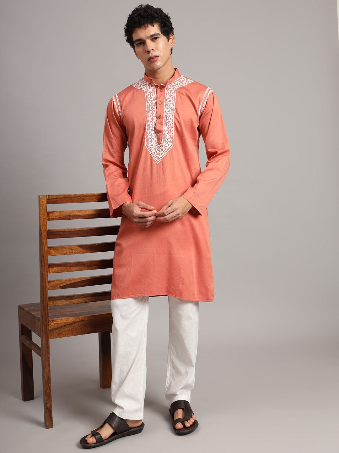 Uman Mens Kurta paired with trousers for a contemporary ethnic outfit, showing long sleeves, a knee-length hem and intricate embroidery framing the collar and placket.