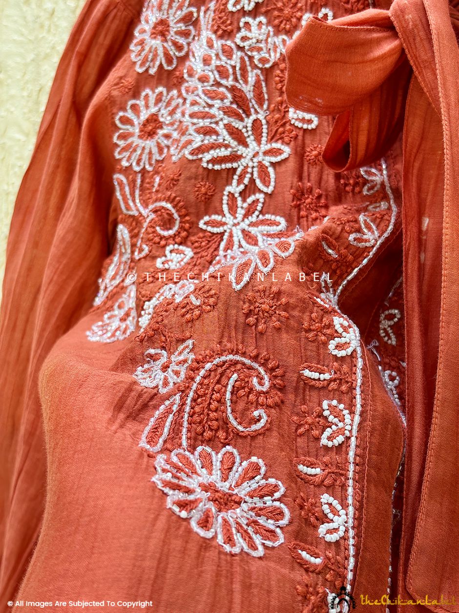 Designer Mulmul Chanderi shirt with delicate handmade embroidery folded aesthetically with warm lighting for a rich feel