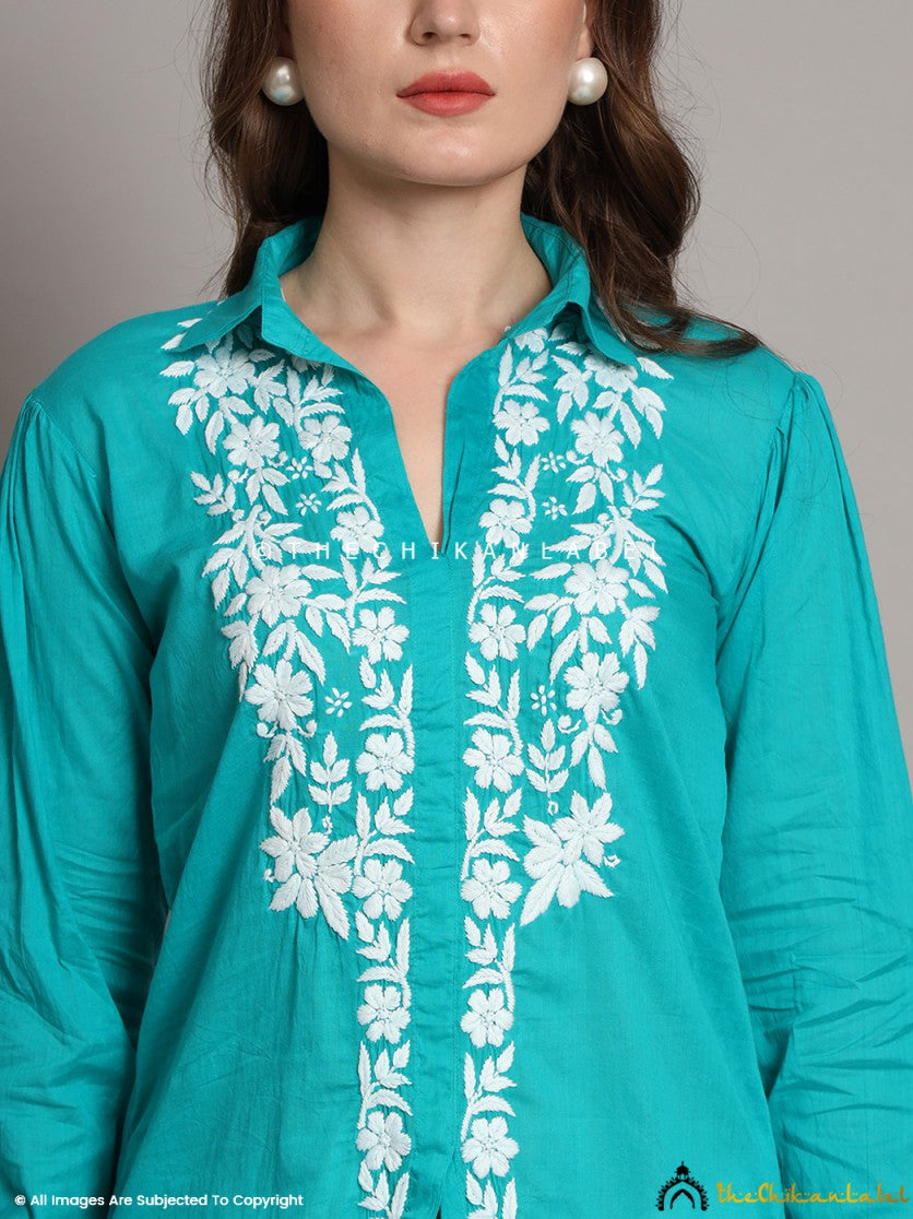 Front view of green cotton shirt styled with white trousers