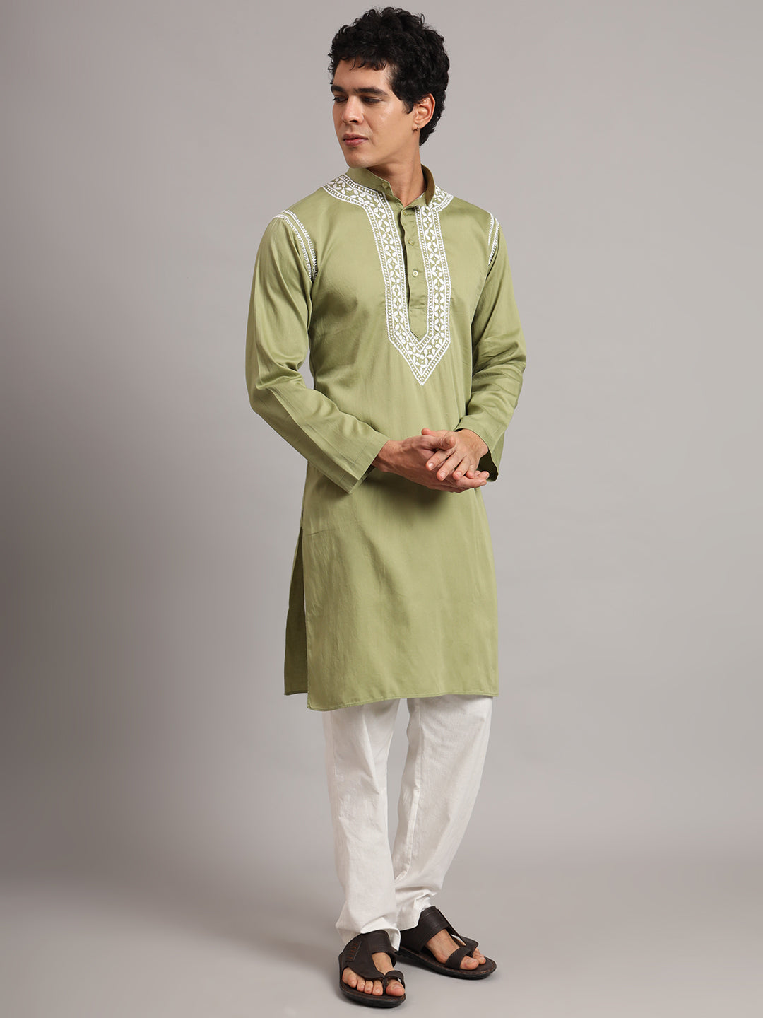 Uman men's Chikankari kurta with a mandarin collar, button fastening and intricate embroidered chest detailing, shown in a full-length outfit with traditional sandals.