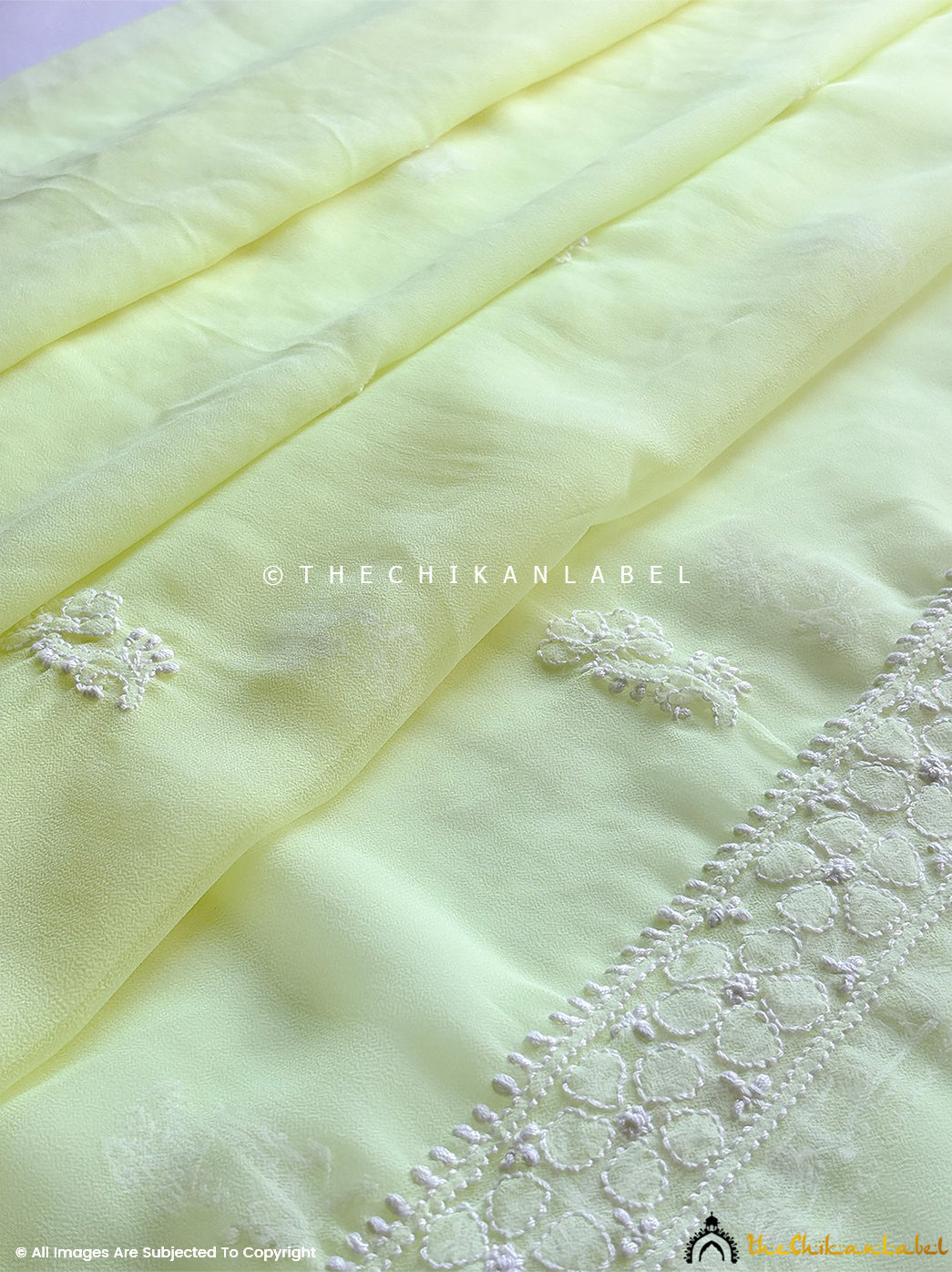 “Close-up of detailed hand-embroidered chikankari work on unstitched georgette suit material with dupatta”