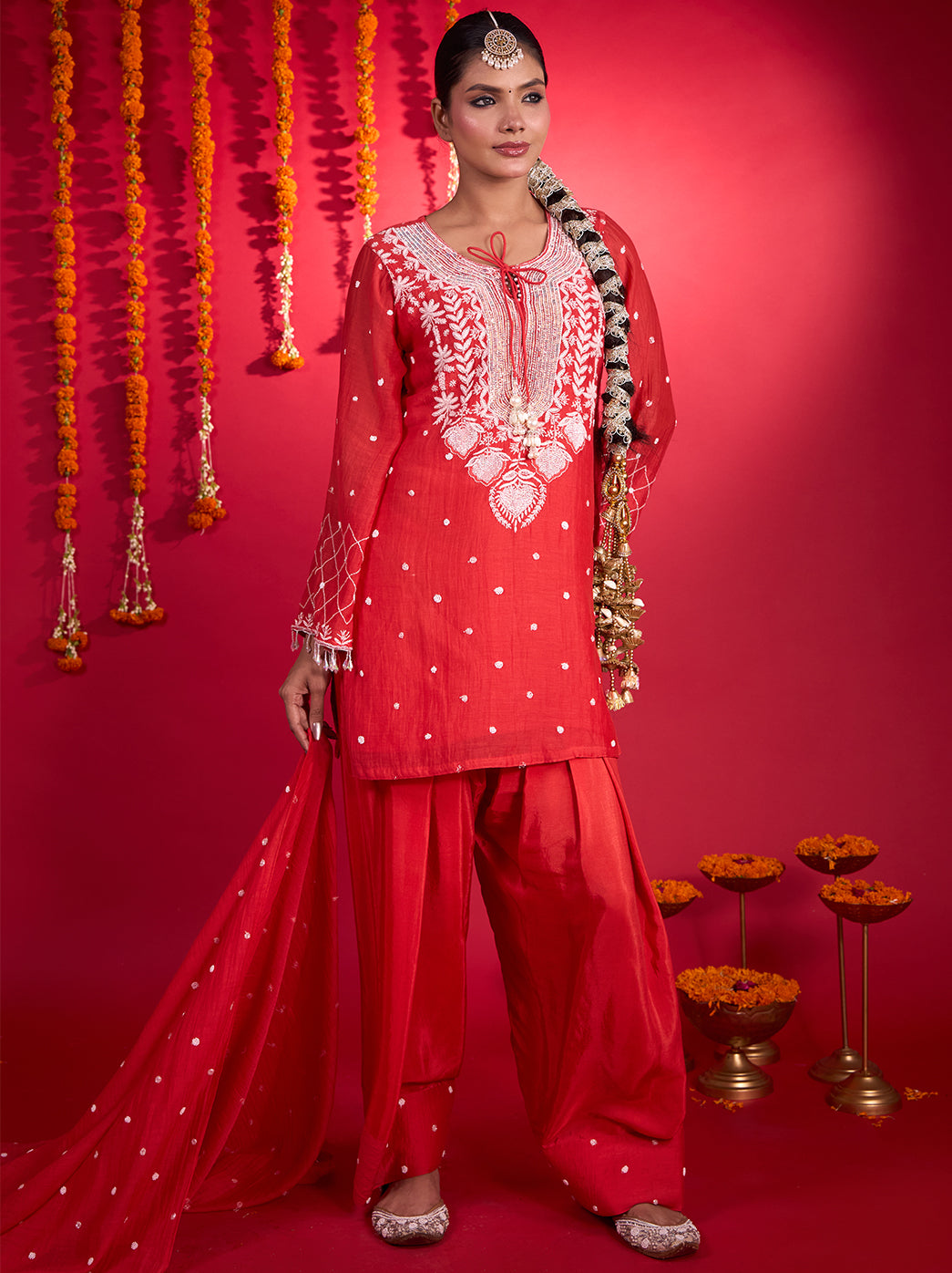 Model showcasing a Mul Chanderi kurta with floral and leaf Chikankari motifs around the neckline, paired with matching pants and an embroidered dupatta.