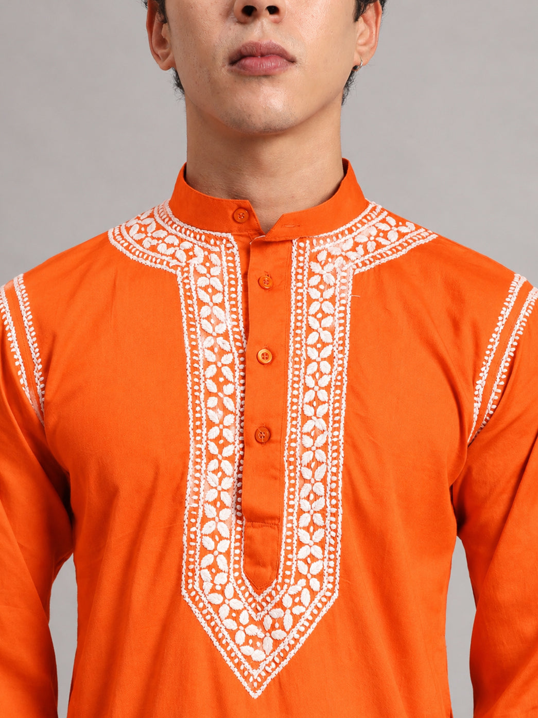 Studio photograph of the Uman Mens Kurta showing its front buttons, structured collar and narrow shoulder embroidery, with the model standing upright facing the camera.