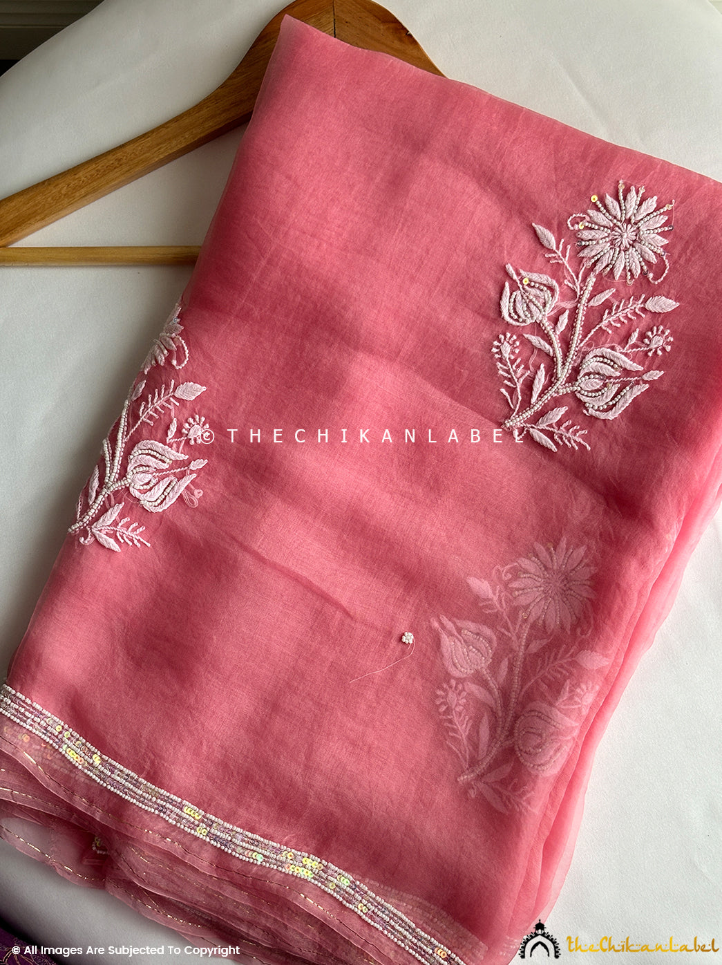 Elegant organza chikankari saree with intricate hand embroidery and pearl embellishments ideal for bridal trousseau and festive events.