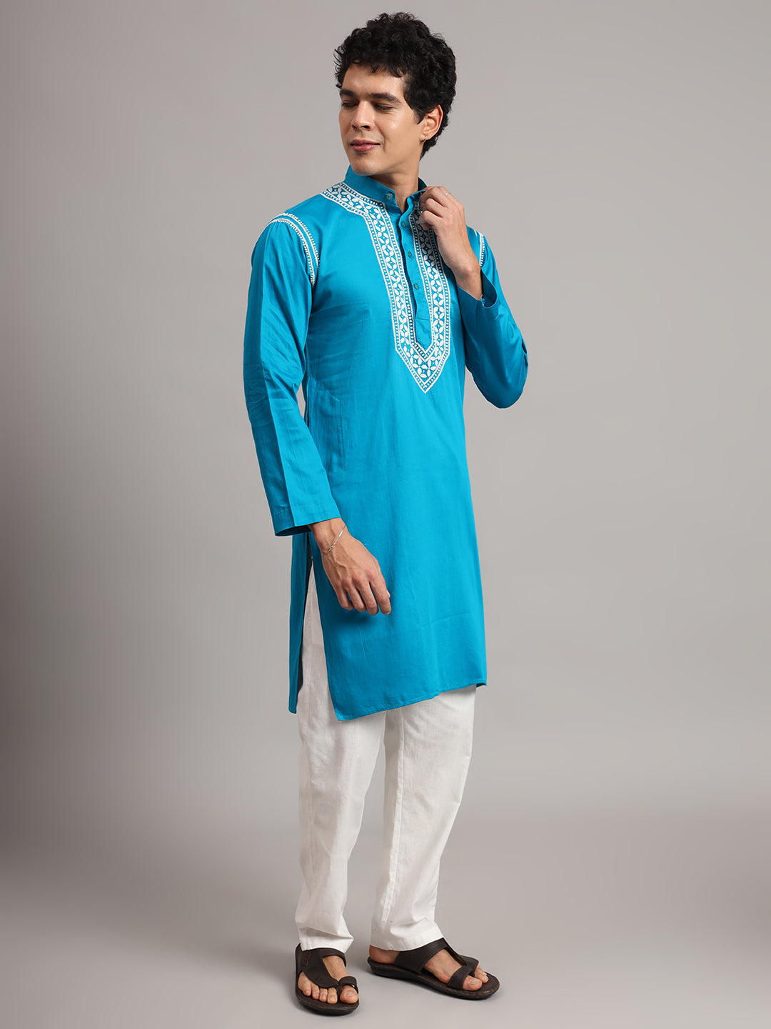 Full-length product photograph of the Uman Mens Kurta, with decorative embroidery framing the neckline and shoulder seams above an otherwise unembellished kurta body.