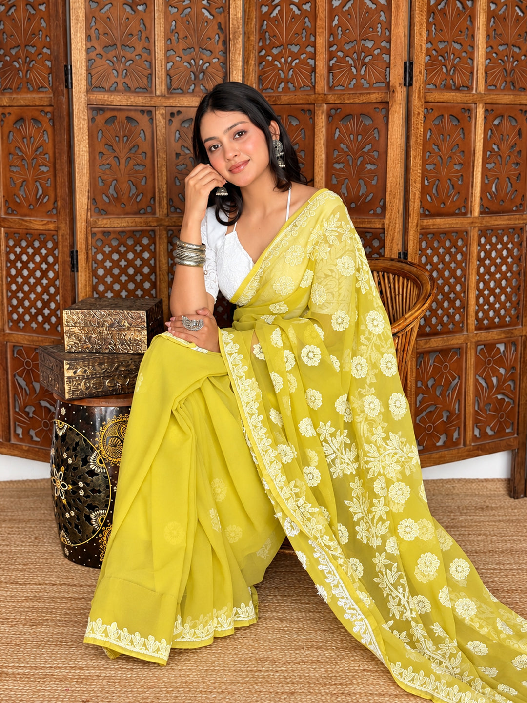 Front view of the Pranshi Georgette Chikankari Saree showing neatly arranged pleats, embroidered floral motifs and a flowing pallu.