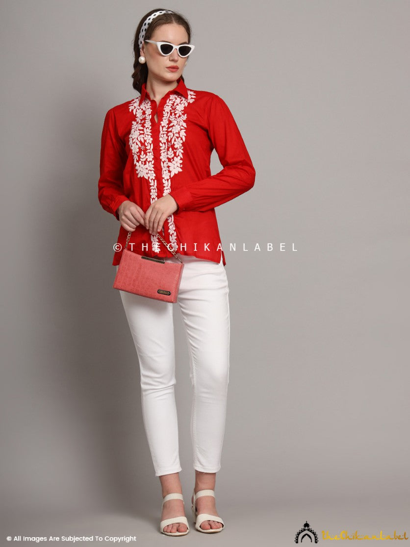 Model showcasing office look with red embroidered shirt and minimal accessories