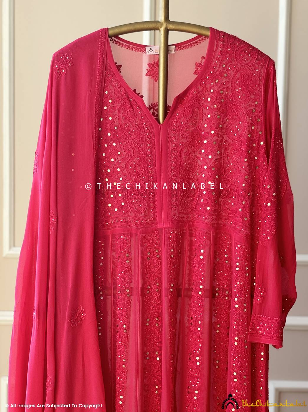 Traditional red embroidered Anarkali set displayed on stand