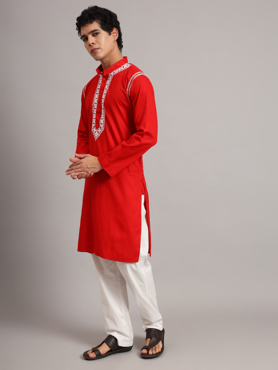 Uman Chikankari kurta for men photographed against a plain studio backdrop, showing long sleeves, a straight hem and side slits above the trouser legs.