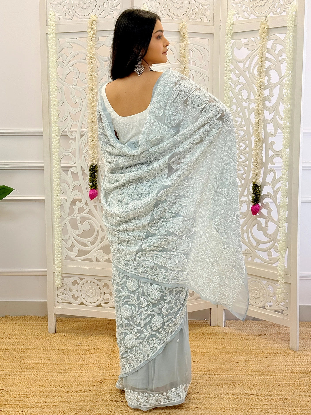 Soft-flowing georgette saree with exquisite hand chikankari detailing captured in a festive ethnic setting.