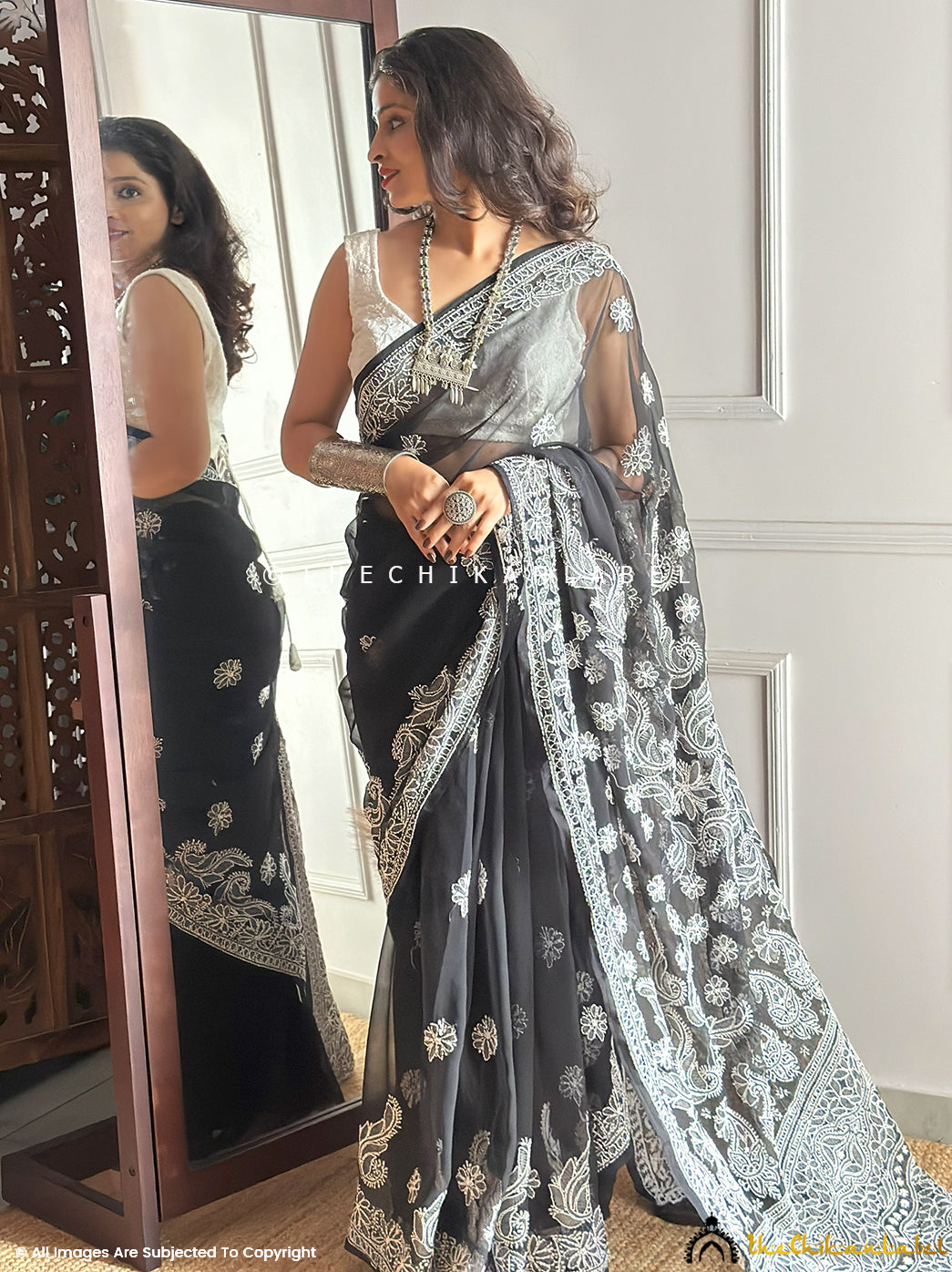 Full-length image of model showcasing trending georgette chikankari saree featuring traditional Lucknowi embroidery with floral and paisley motifs, perfect for festive occasions.