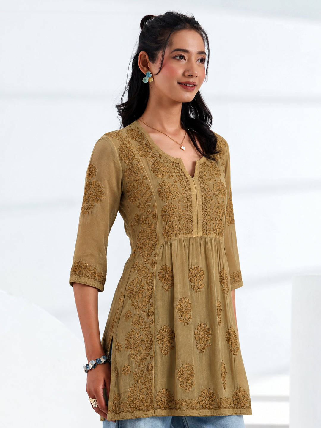 Women's viscose silk Chikankari short kurti with detailed floral embroidery on the front bodice, decorative neckline, embroidered sleeve borders, and stylish A-line design.