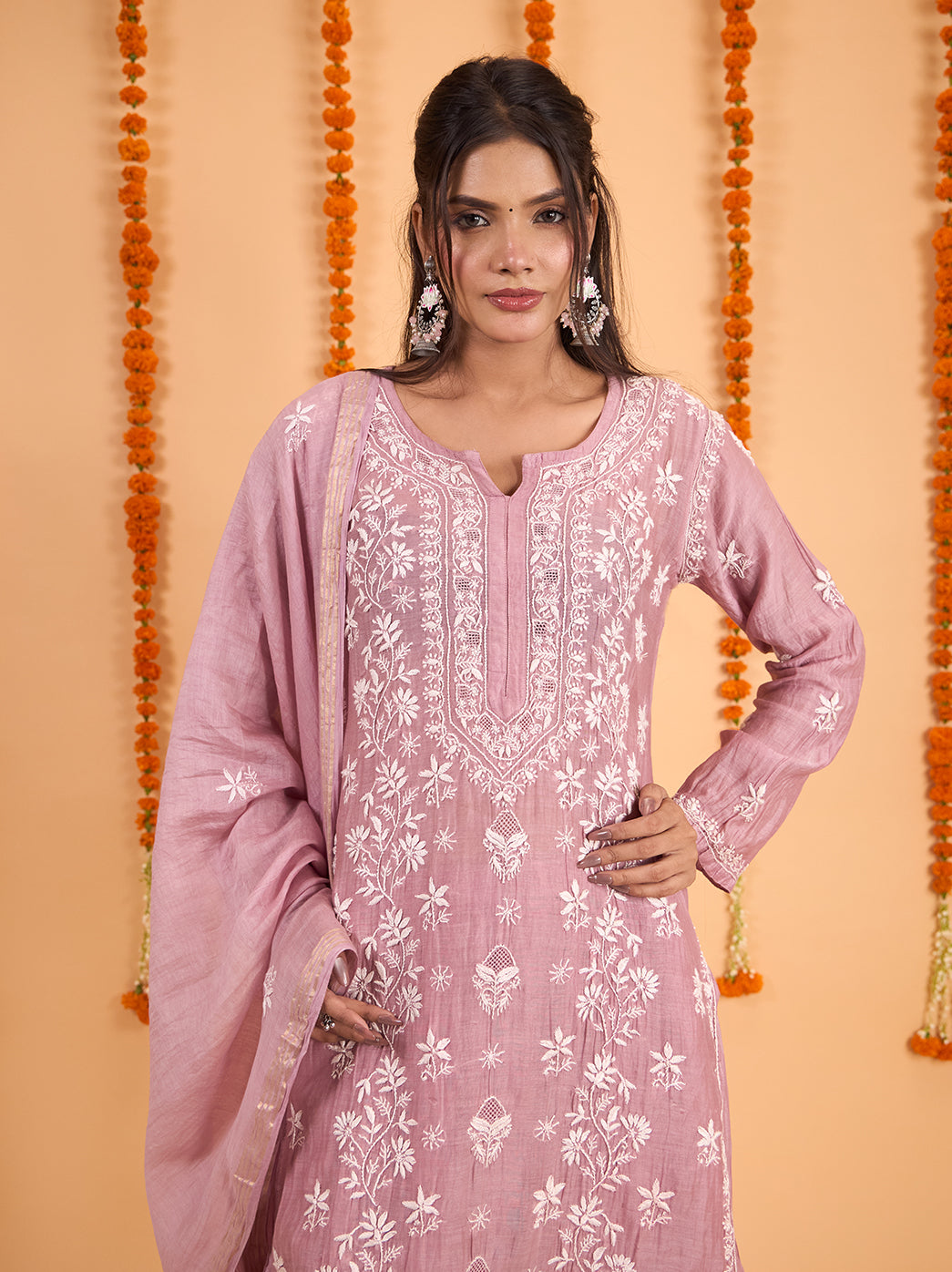 Model posing with one hand on her hip in the Sofia Chikankari Kurta Set with Dupatta, styled with statement earrings, a ring and embellished juttis.