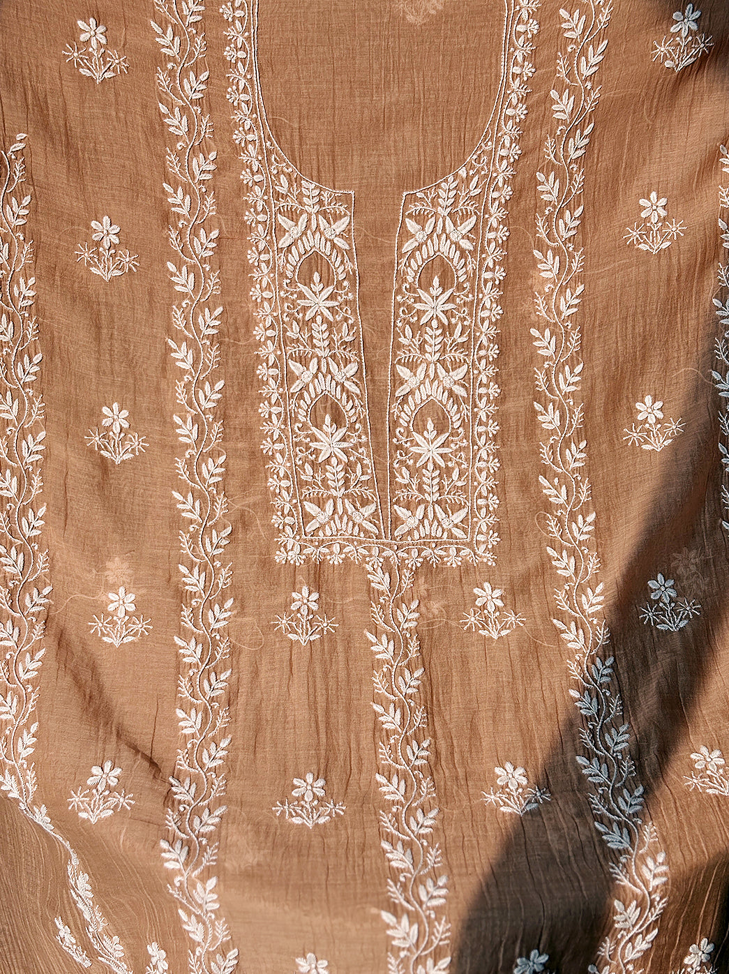 Close-up view of Mul Chanderi unstitched kurti fabric with intricate hand-embroidered Chikankari neckline and floral vine motifs.