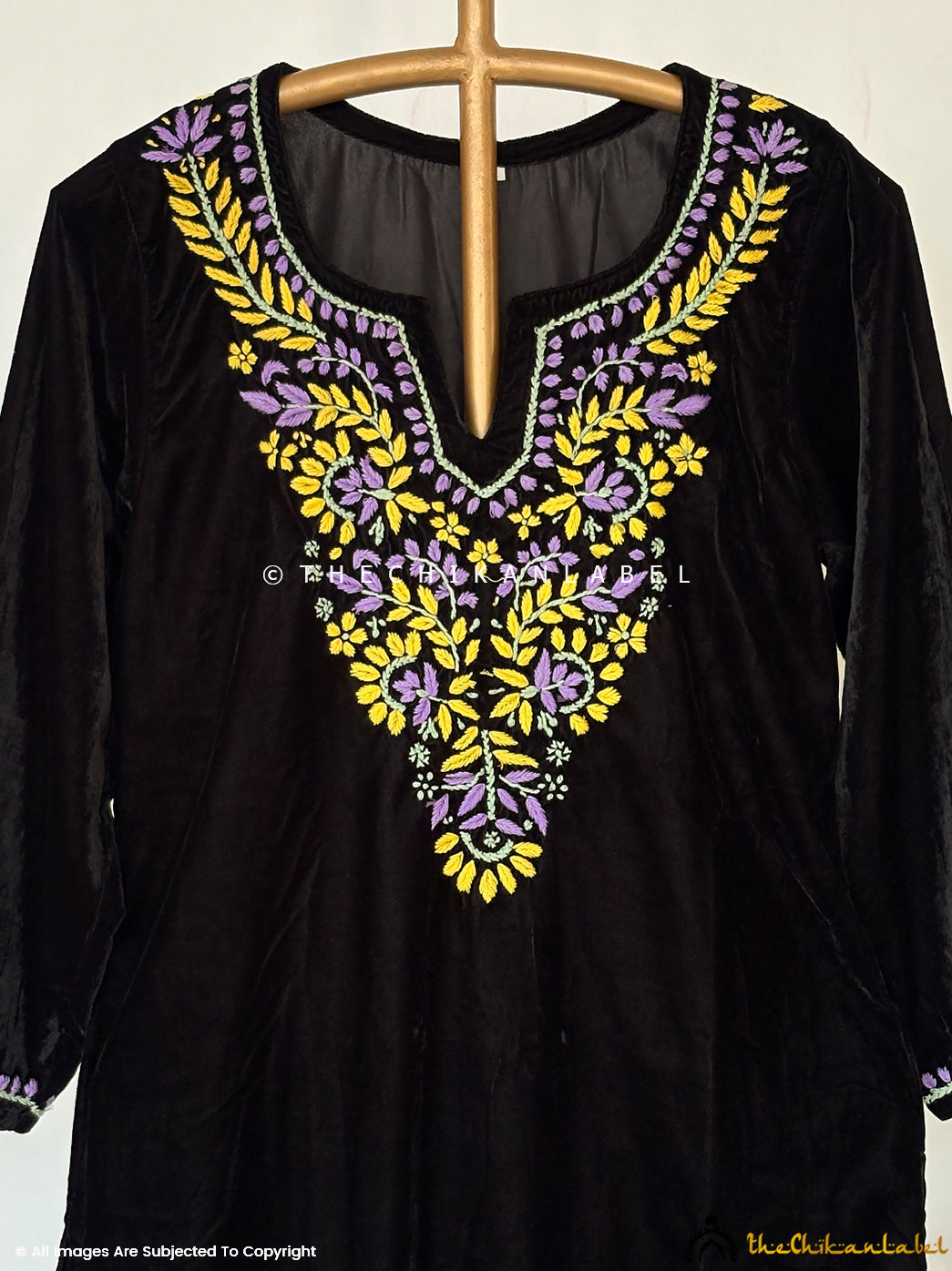 Artisan-crafted velvet chikankari straight kurta set showcasing detailed neckline embroidery and coordinated festive bottoms.