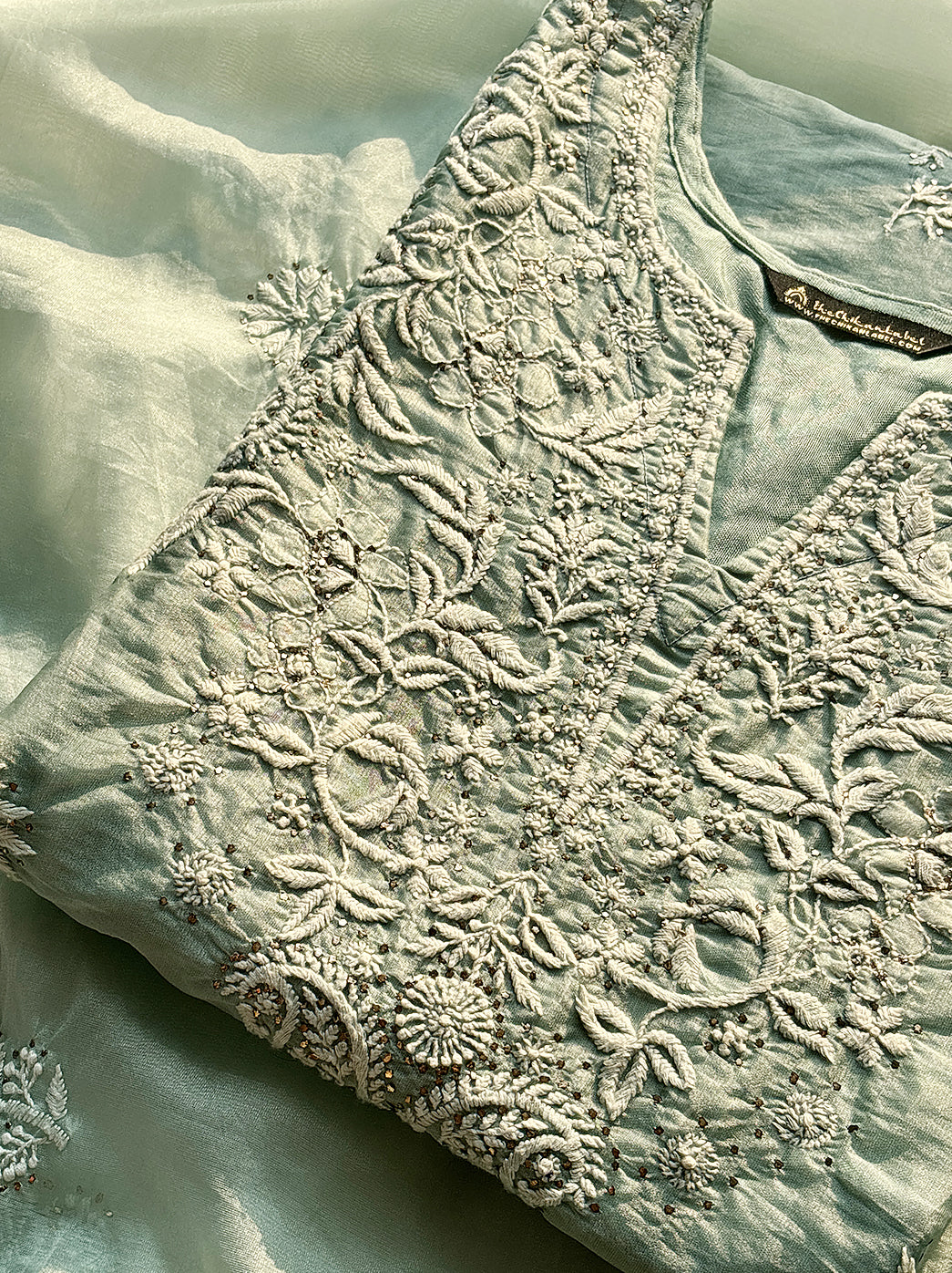 “Front view of organza chikankari stitched kurti paired with embroidered dupatta and straight pants”