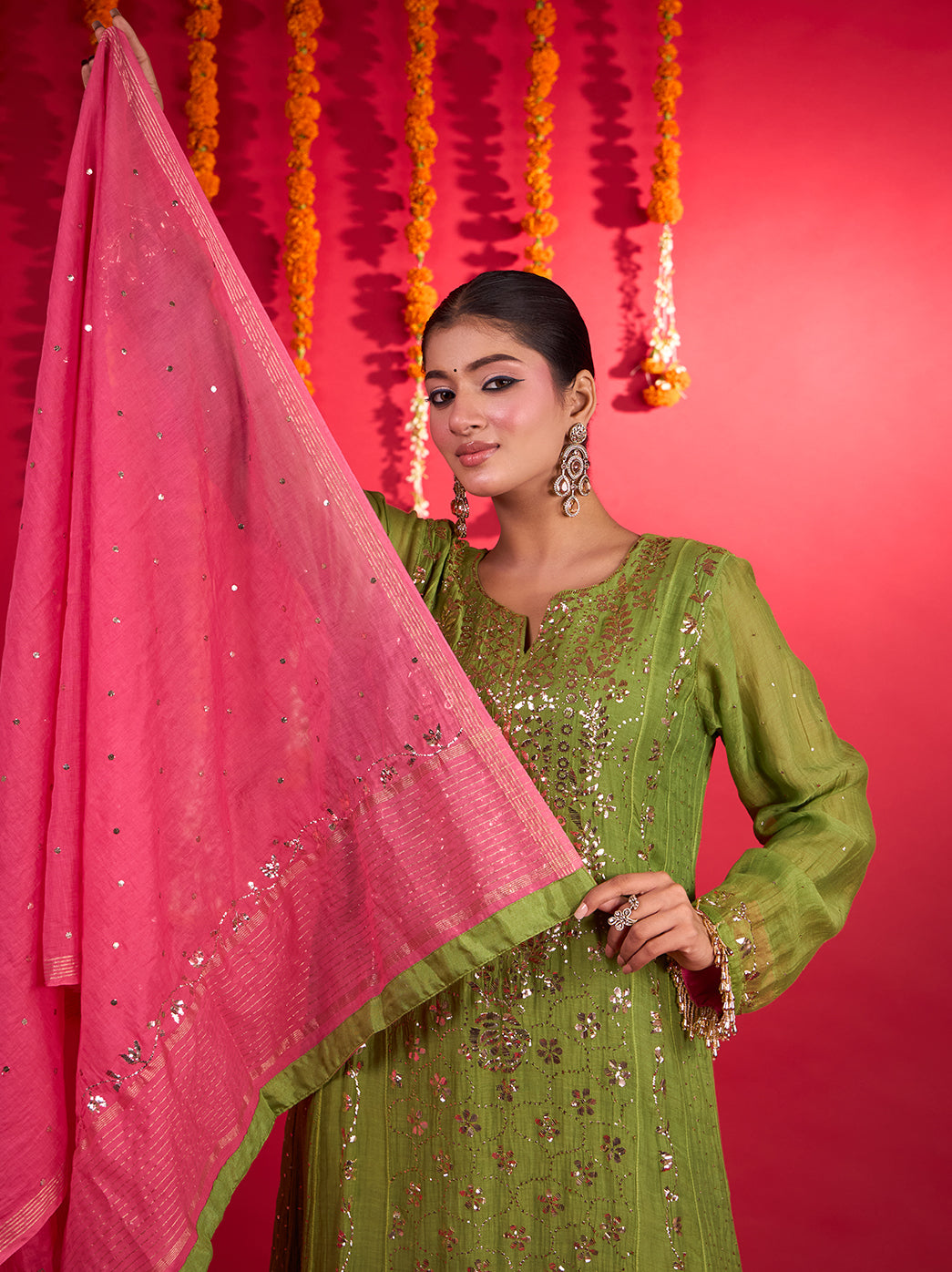Tehzeeb Kurta Set with Dupatta featuring a straight silhouette, side slits and scattered floral motifs, photographed with hanging marigold garlands and decorative brass stands.
