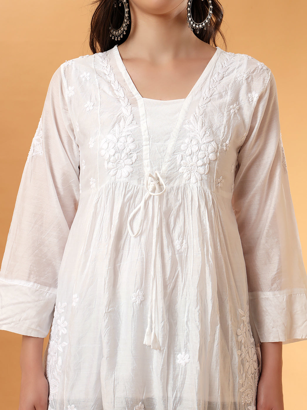 Close-up of V-neckline and tie-up detail with floral hand embroidery.