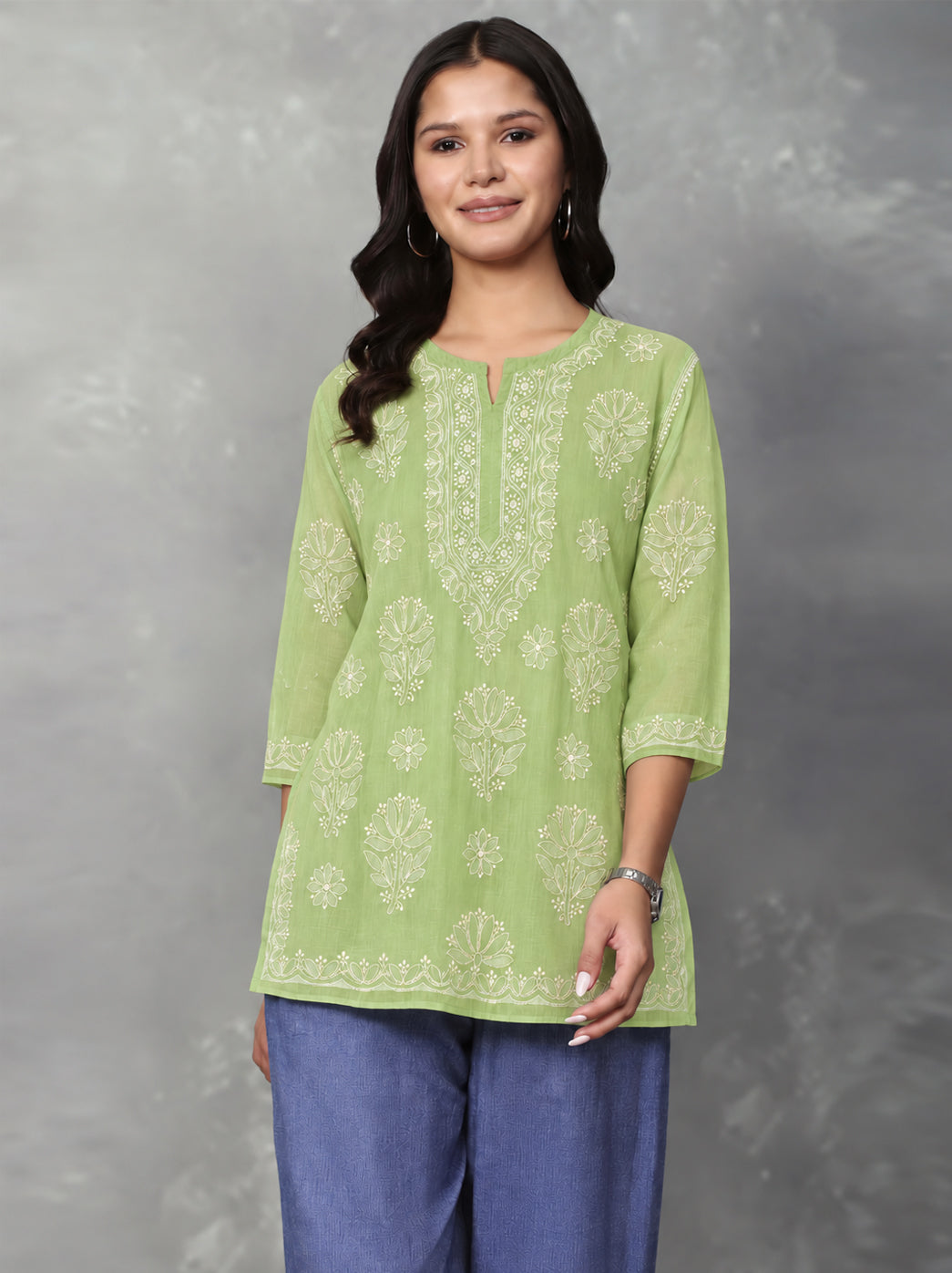 Cotton Chikankari kurti with an elongated embroidered neckline panel, alternating floral motifs across the front and a decorative border along the lower hem.