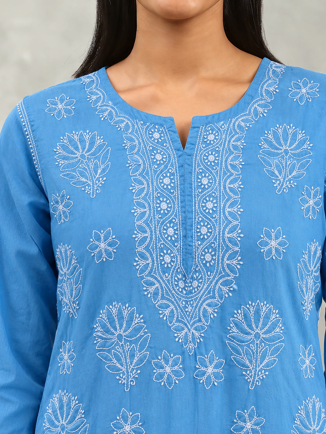Front view of the Ziva Cotton Short Kurti showing scattered floral motifs, an intricately embroidered neckline and decorative detailing along the hem.