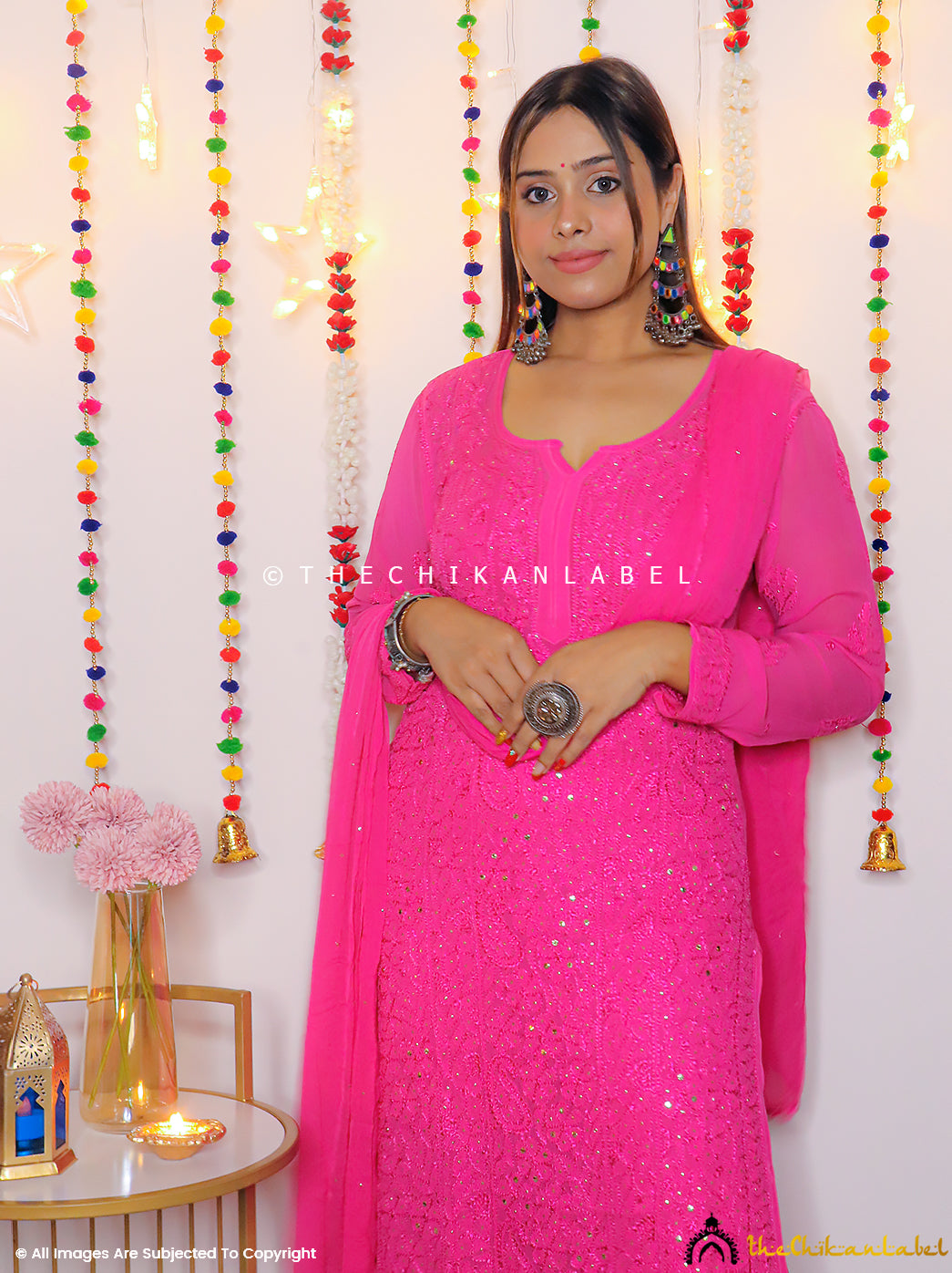 Elegant hot pink chikankari embroidered kurta set featuring handwork details, styled with juttis and festive backdrop.