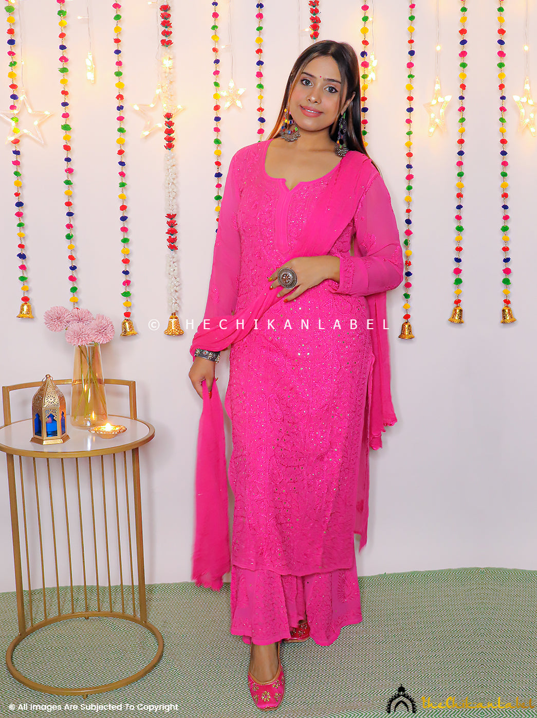 Woman wearing hot pink viscose chikankari kurta set with matching palazzo and dupatta, styled for festive wear.