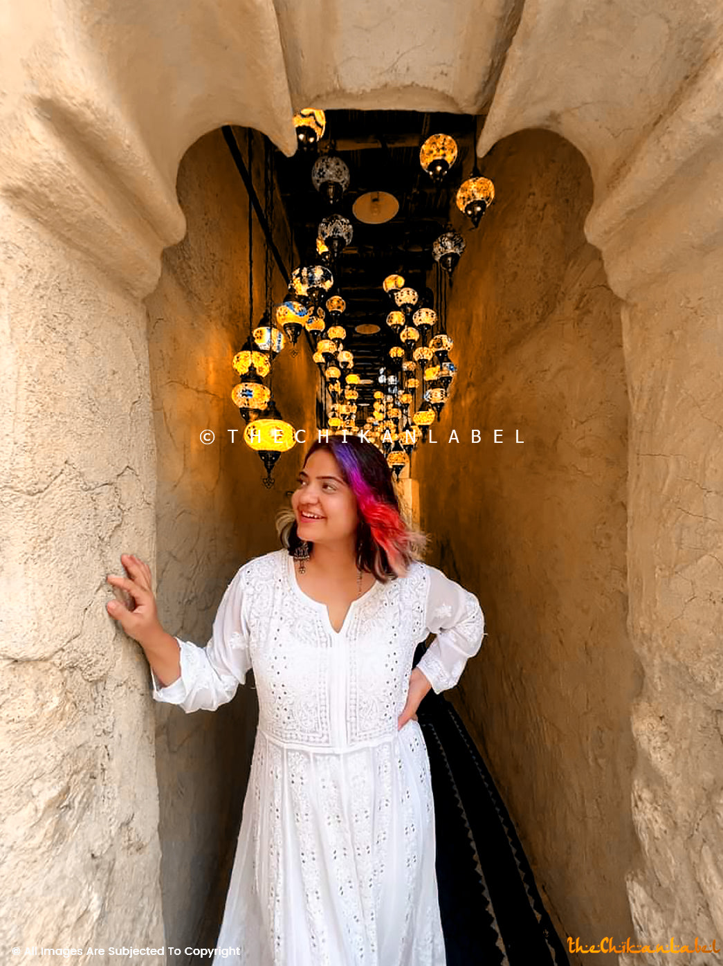Front view of all-white Lucknowi embroidered Anarkali dress styled in a cultural setting