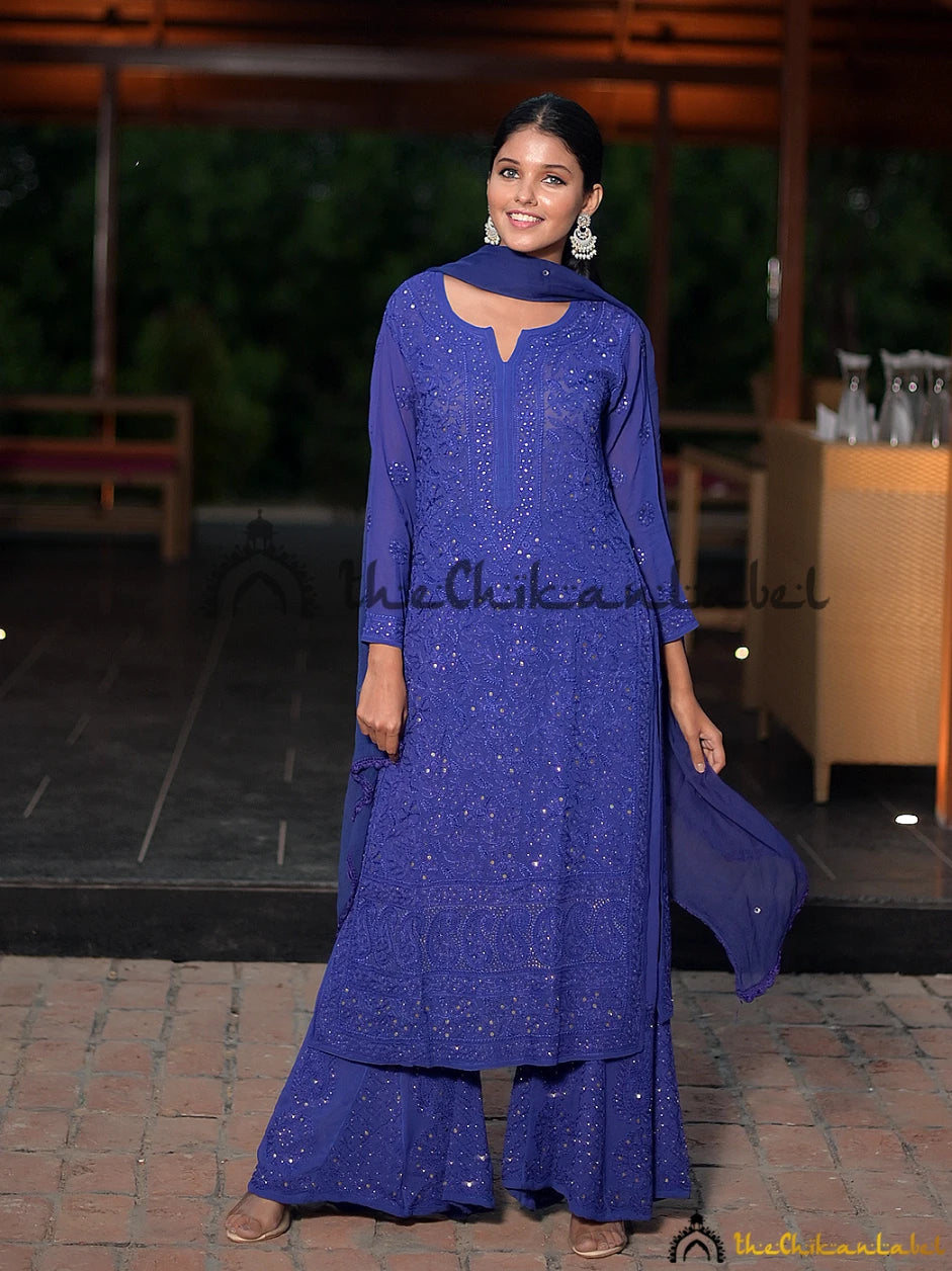 Full front view of model in royal blue chikankari kurta set with mirror embellishments and chiffon dupatta.