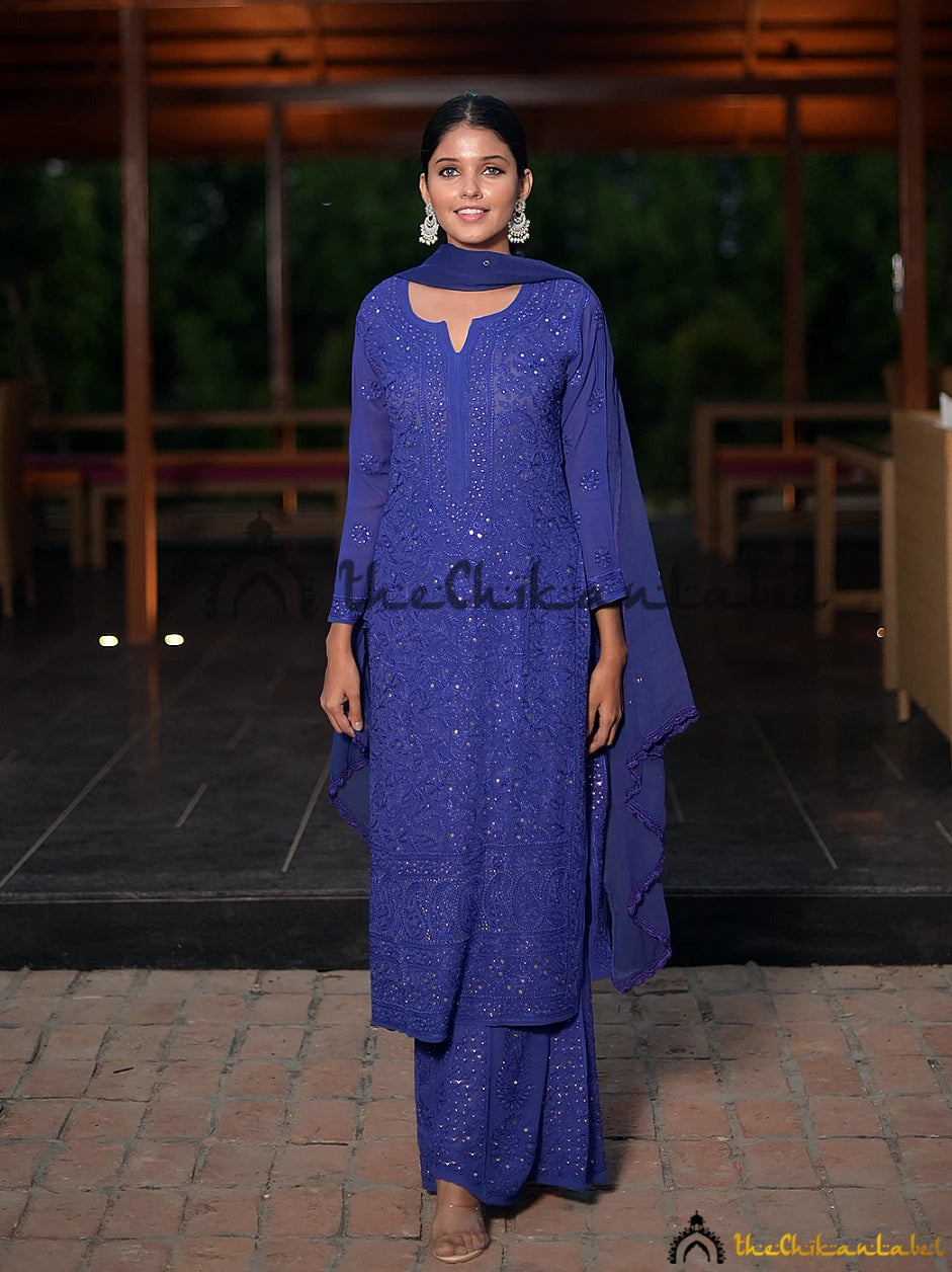 Evening outdoor shot of model styled in royal blue chikankari suit, accessorised with silver jhumkas.