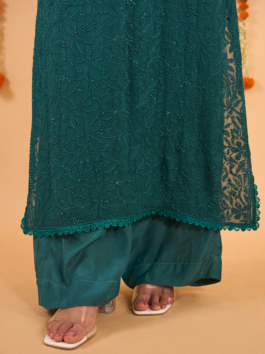 Festive styling of the Adaah viscose Chikankari kurti palazzo set with dupatta, accessorised with statement bangles, a ring and embellished footwear.