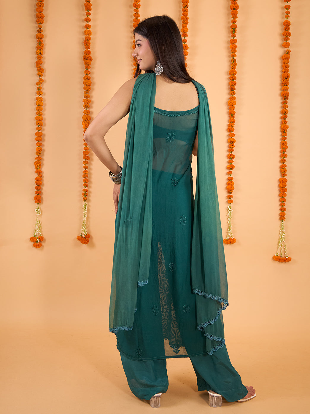 Adaah sleeveless strappy kurti with floral Chikankari motifs extending down the front, styled with matching palazzo pants for festive dressing.