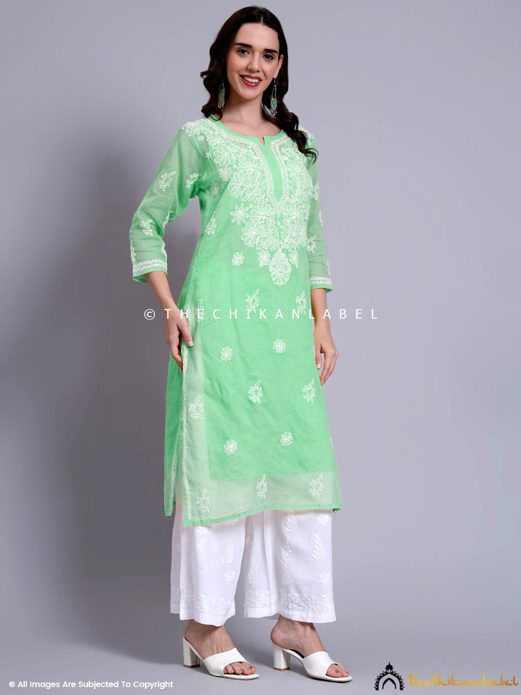 Kota cotton kurti with detailed white embroidery and semi-sheer texture, paired with contrast bottoms and ethnic earrings for festive styling.

