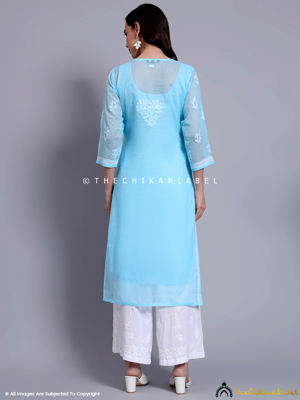 Lightweight Indian kurti made from Kota cotton featuring artisan chikankari floral embroidery, styled with ethnic bottoms and heels.

