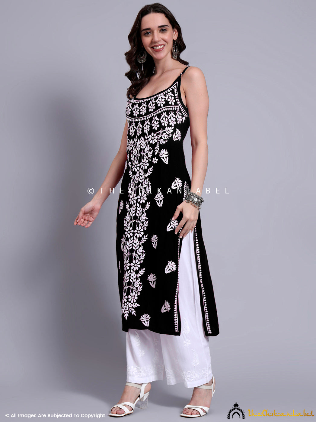 Indo-western ethnic outfit featuring long sleeveless kurta in modal with traditional embroidery motifs on neckline and center panel.

