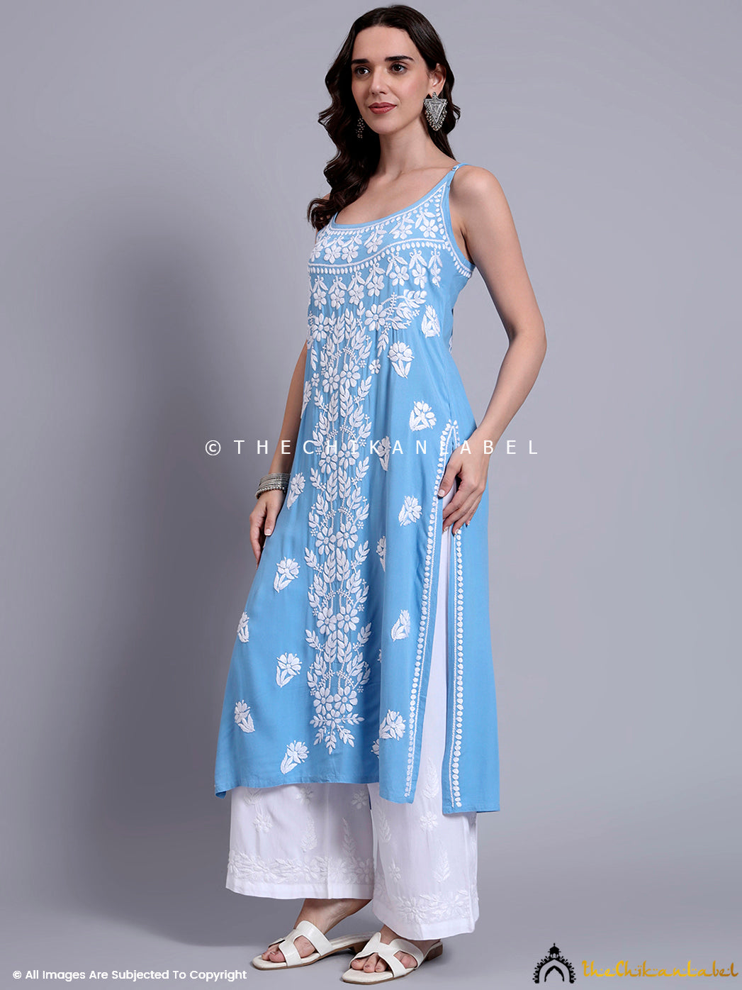 Model posing in a breathable modal chikankari kurta with long straight cut and sleeveless strappy neckline for warm weather wear.

