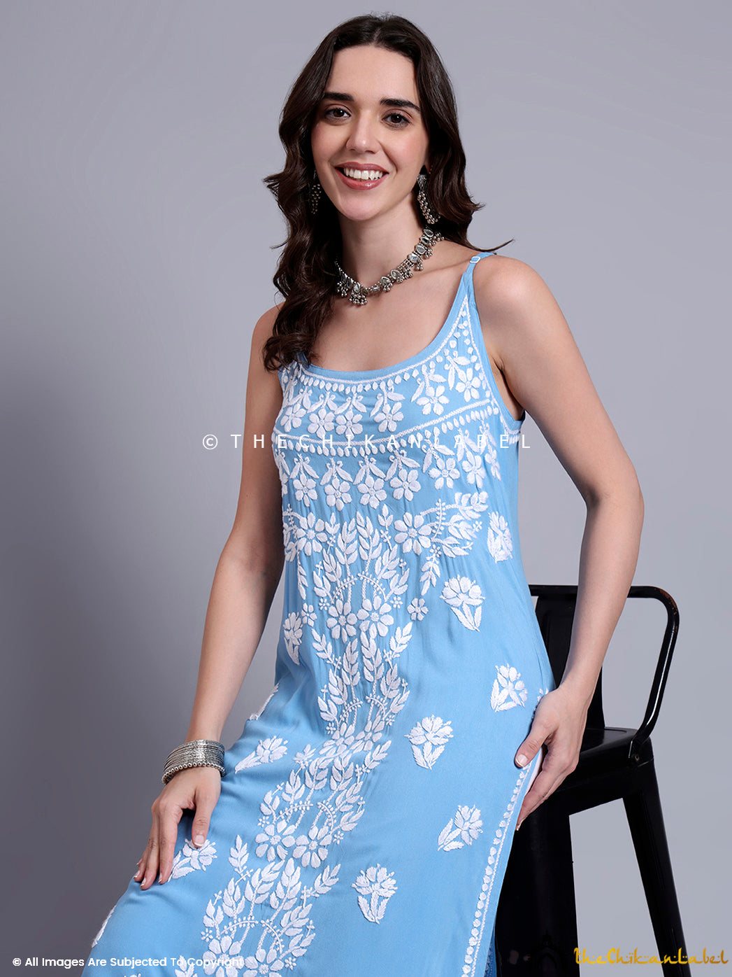 Front-facing image of woman in chikankari long kurta with strappy design and handcrafted embroidery, ideal for ethnic summer styling.

