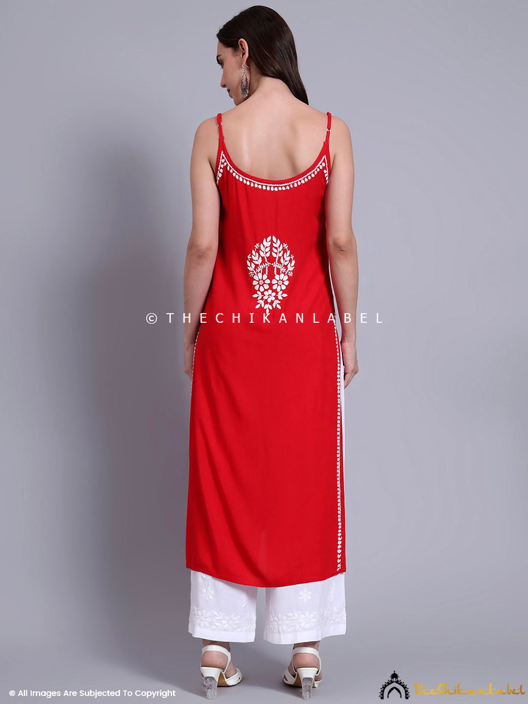Fashion model dressed in a modal chikankari strappy kurta with straight silhouette, side slits, and traditional embroidery for summer ethnic styling.

