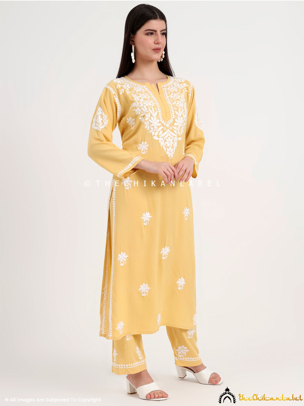 Ethnic chikankari kurti set with intricate neckline embroidery and scattered motifs across the fabric.
